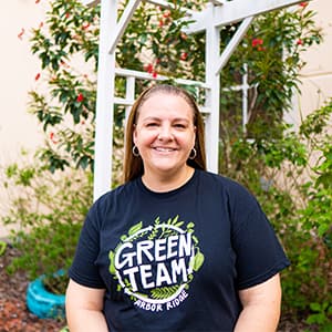 Amanda Ferguson smiles in front of a garden.