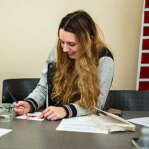 Student smiling and painting