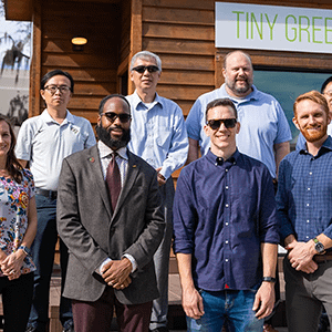 The REACH team stands in front of a "tiny green home" the mobile hubs were inspired by