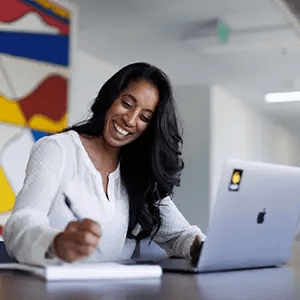 Woman smiling and writing notes