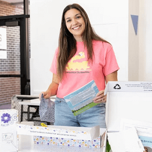 Kelly Shea ’23 smiling while standing behind display table