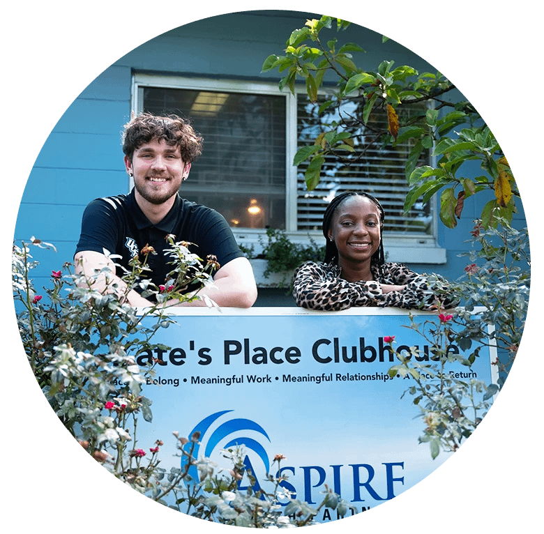 Students smiling behind a Kate's Clubhouse - ASPIRE sign