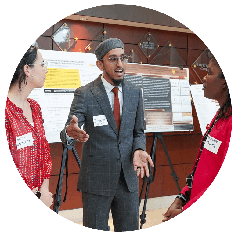 Three students conversing at showcase