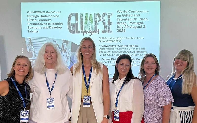Group of female members standing together at a professional association presentation 